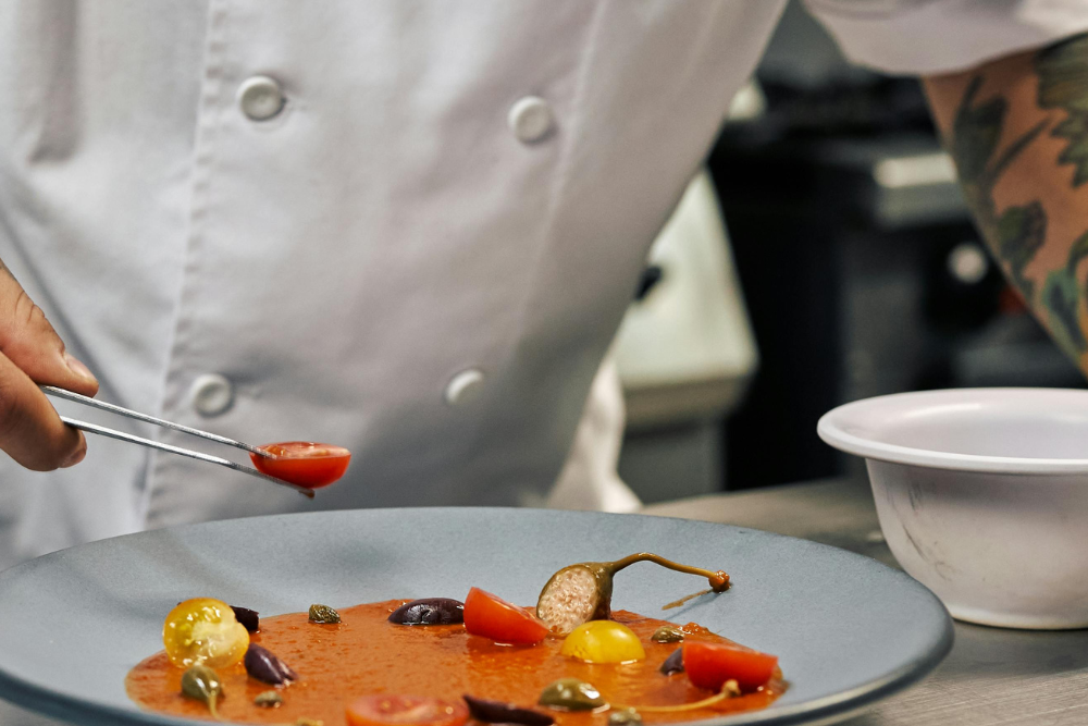 production chef assembling a plate in kitchen
