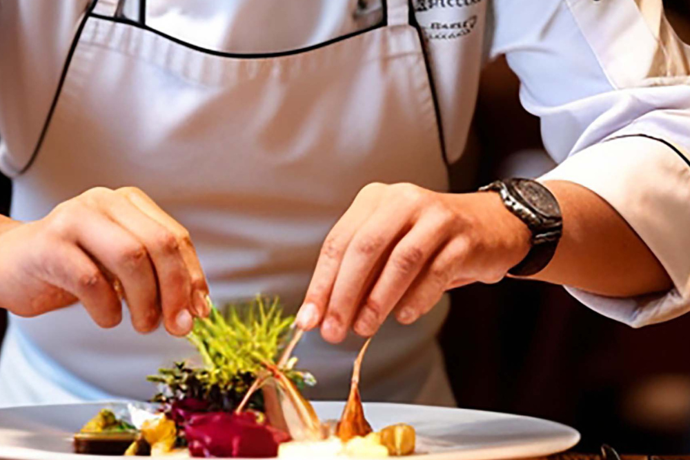 Senior Production Chef assembling a dish in the kitchen