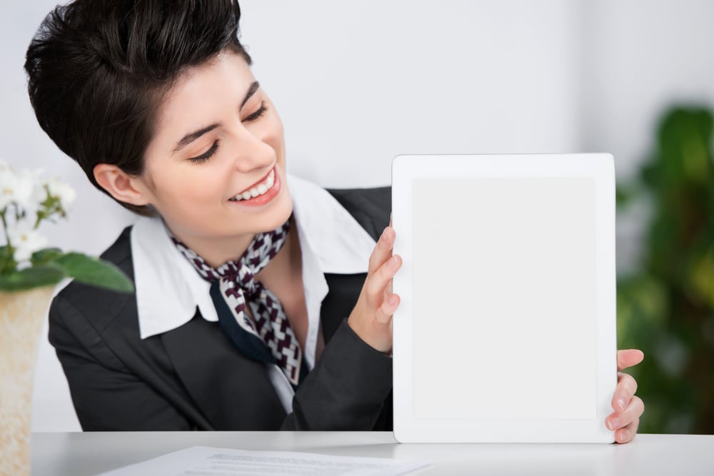 Customer service practitioner showing and smiling at a blank tablet screen