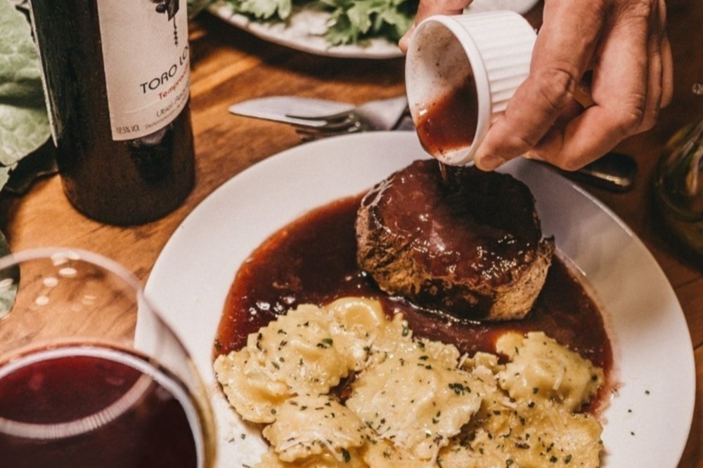 sauce being poured over a meal
